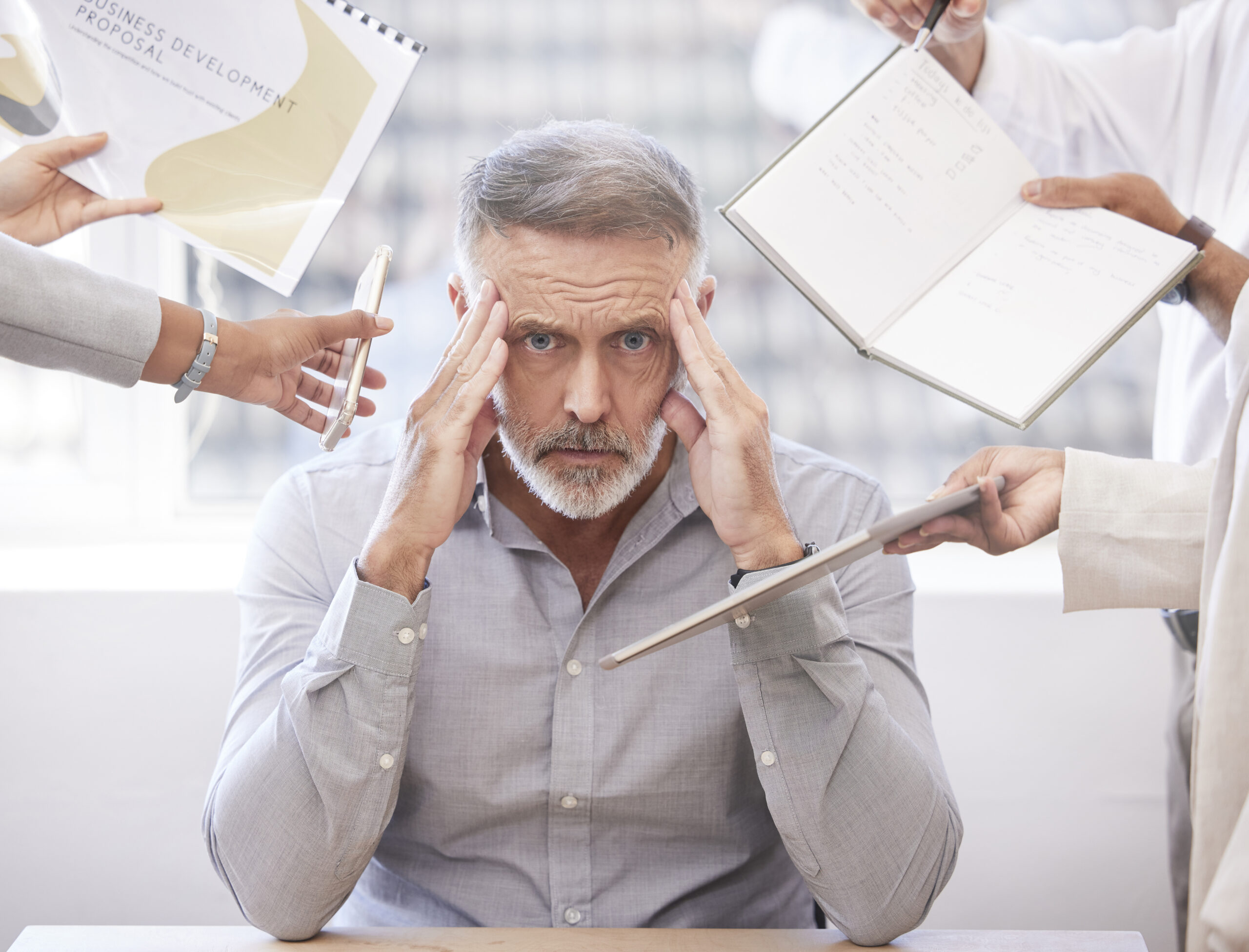 Man sat with a headache due to many things happening around him